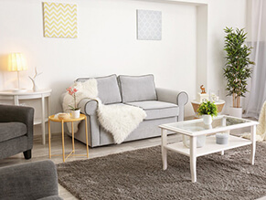 Cosy_neutral_living_room_fluffy_rug_floor_white_coffee_table_floorboards_yellow_artwork